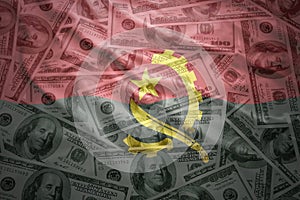 Colorful waving angolan flag on a dollar money background