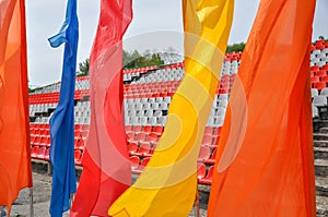 Colorful waving flags and empty seats in the stands of the arena