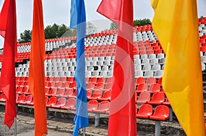 Colorful waving flags and empty seats in the stands of the arena