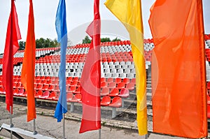 Colorful waving flags and empty seats in the stands of the arena