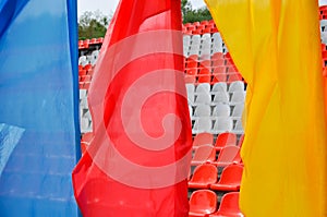 Colorful waving flags and empty seats in the stands of the arena