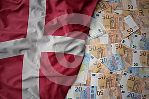 colorful waving national flag of denmark on a euro money background. finance concept