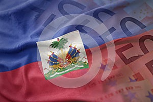 Colorful waving national flag of haiti on a euro money banknotes background.