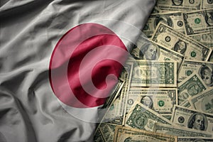 colorful waving national flag of japan on a american dollar money background. finance concept