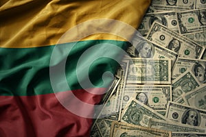 colorful waving national flag of lithuania on a american dollar money background. finance concept