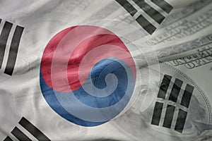 Colorful waving national flag of south korea on a american dollar money background.