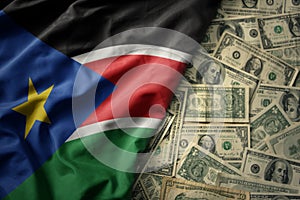 colorful waving national flag of south sudan on a american dollar money background. finance concept