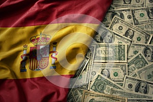 colorful waving national flag of spain on a american dollar money background. finance concept