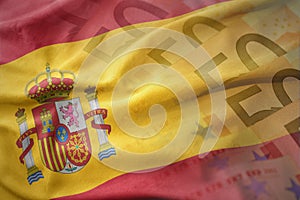 Colorful waving national flag of spain on a euro money banknotes background.