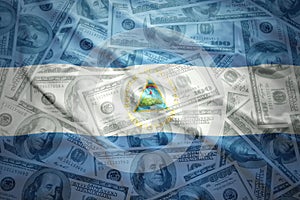 colorful waving nicaraguan flag on a dollar money background