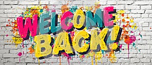 Colorful Welcome Back graffiti on brick wall
