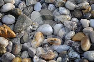 Colorful wet pebbles on the beach.Colorful wet pebbles at the beach. Pebble background image.