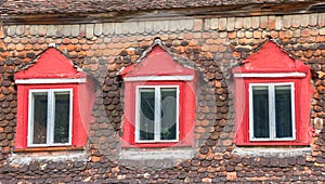 Colorful windows and roof tiles on a house in Sighisoara