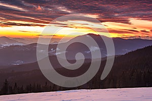 Colorful winter morning in the mountains. Dramatic overcast sky.