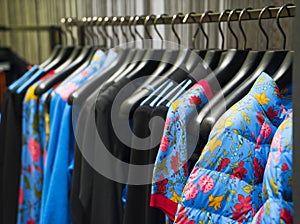 Colorful Women`s dresses on hangers in a fashion store. Shop stylish clothes, close-up. - image.