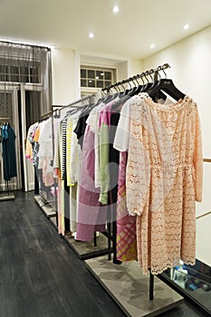 Colorful Women`s dresses on hangers in a fashion store. Shop stylish clothes, close-up. - image.