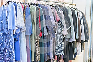 Colorful women's dresses on hangers in a retail shop. Fashion and shopping concept. Hanger with clothes in the store