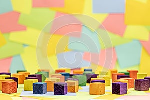 Colorful wood block with a background of multicolored paper sticky notes