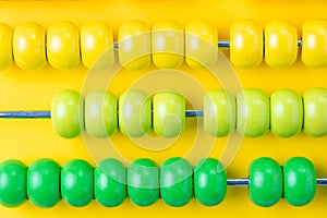 Colorful wooden abacus beads on vivid yellow background, business financial or accounting profit and loss concept, or use in