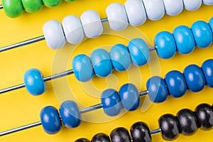 Colorful wooden abacus beads on yellow background, business financial or accounting cost and expense calculation concept, or use