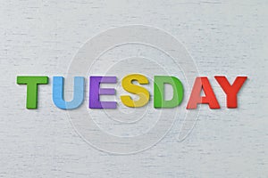 Colorful wooden alphabet with text TUESDAY. A happy Tuesday concept