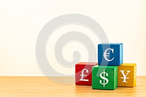Colorful wooden blocks with symbols of major currencies in the world, Dollar, Euro, British Pound and Chinese Yuan, Concept of