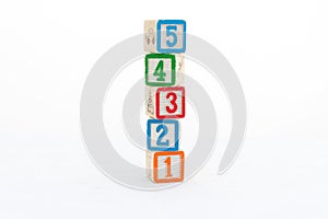 Colorful wooden blocks tower with 5, 4, 3, 2, and 1 numbers isolated on white background