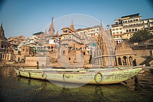 Colorful wooden boats docked along the shore of the Ganges River, at one of the many ghats in Varanasi, India.