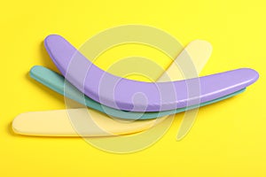 Colorful wooden boomerangs on yellow background. Outdoor activity