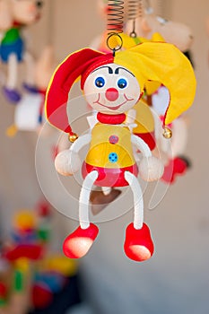 Colorful wooden buffoon figure hanging on the spring