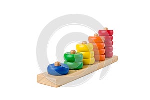 Colorful wooden children toy scores from one to five figures of the colored rings isolated on a white background. Focus stacking.