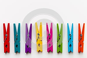 Colorful wooden clothespins on white background with copy space/diversity concept