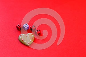 Colorful wooden cube beads with letters on red festive background, word `love`. Valentine Day. 14 of February. Flat lay,