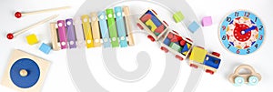 Colorful wooden educational and musical toys for baby kids on white background. Top view, flat lay frame