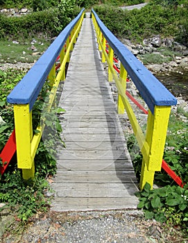 Colorful wooden footbridge over small stream. Hospital Bay, Madeira Park, Sunshine Coast, BC, Canada