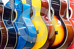 colorful wooden guitars hanging on wall of store showroom