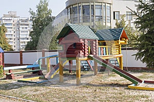 Colorful wooden house with slider on empty playground