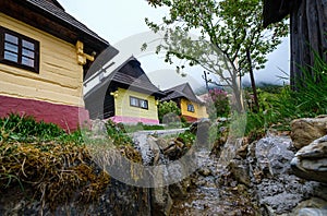 Farebné drevenice v obci Vlkolínec s potôčikom, Slovenská republika, UNESCO. Kultúrne dedičstvo.