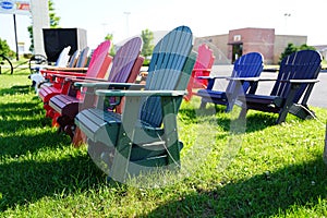 Colorful wooden lawn chairs set up outside to be sold in the fond du Lac, Wisconsin area during the summer for people to buy.