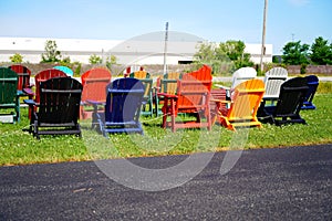 Colorful wooden lawn chairs set up outside to be sold in the fond du Lac, Wisconsin area during the summer for people to buy.