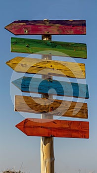 Colorful wooden signpost against blue sky. Perfect for travel, choices, adventure