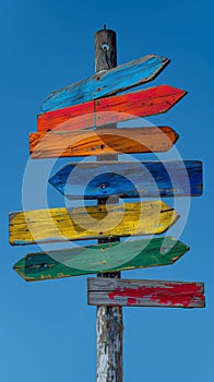 Colorful wooden signpost against blue sky. Perfect for travel, choices, adventure