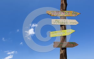 Colorful wooden signs against a blue sky