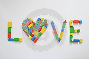 Colorful wooden toy blocks as heart in LOVE