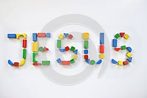 Colorful wooden toy blocks lettering JESUS