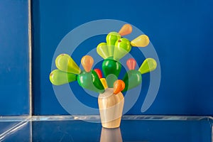 Colorful wooden toy stand alone on clear acrylic shelf against blue wall