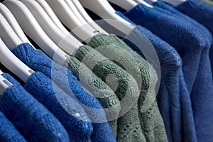 colorful woolen pullover on hangers in a woman fashion store showroom