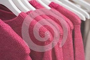 colorful woolen pullover on hangers in a woman fashion store showroom