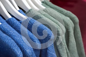 colorful woolen pullover on hangers in a woman fashion store showroom