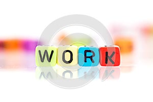 colorful word cube of WORK on a white background